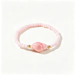 Bracelet en perles roses avec un pendentif en forme de coquillage brillant.