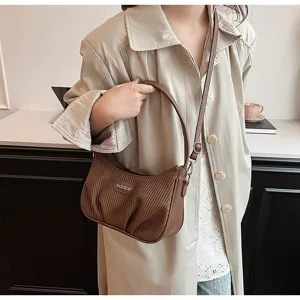 Detailed view of the brown pleated underarm bag, featuring chic vertical folds and dual straps.