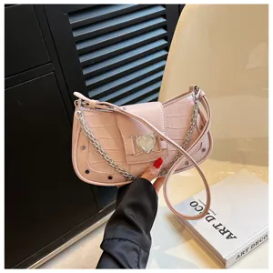 Pink crocodile pattern chain underarm bag, close detail view of the heart metal lock.
