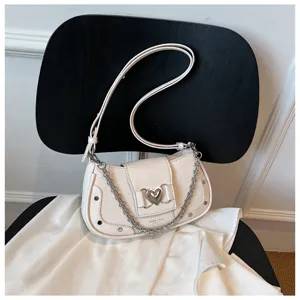 Detailed shot of the white crocodile pattern shoulder bag featuring a silver chain and heart lock.