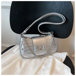 Silver metallic crocodile pattern baguette shoulder bag with chic chain strap and heart buckle.