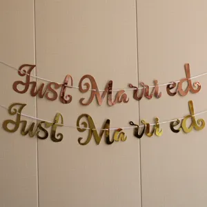 Detailed view of rose gold and gold Just Married letter banners for wedding decoration.