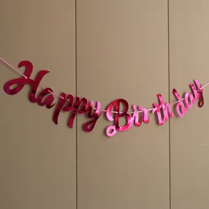 Close up of shiny pink hot stamping happy birthday letter banner party decoration detail view