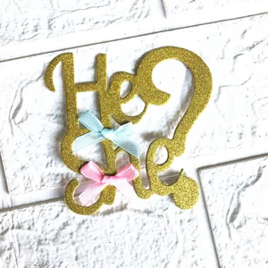 Gold glitter gender reveal cake topper with cute blue and pink bows for party decoration.