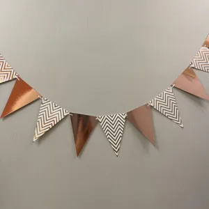 Detail shot of rose gold metallic and chevron triangle bunting banner for festive party decor.