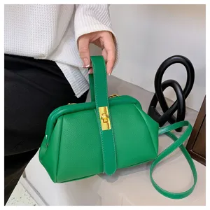 Groene handtas met litchi motief en beugelsluiting, elegante schoudertas detail.