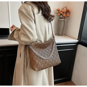 Detail view of the pleated shoulder tote bag with silver chain accessory in casual autumn style.