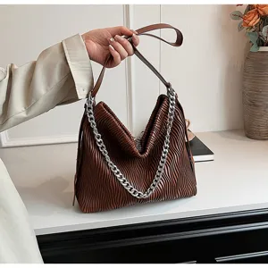 Detailed view of the brown pleated shoulder bag showcasing exquisite craftsmanship and chain.