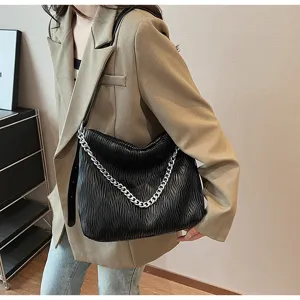 Details of the black pleated shoulder bag with silver chain, showcasing texture and style.