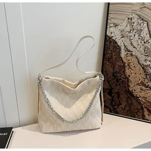 Detailed view of the chic pleated shoulder bag featuring elegant silver chain strap and beige fabric.