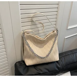 Beige pleated shoulder bag detail, featuring elegant metal chain strap and soft texture design.