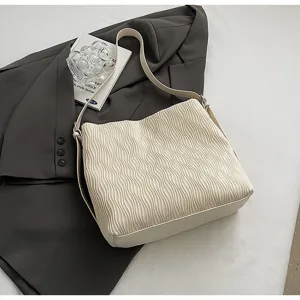 Cream pleated shoulder bag detail, stylish women tote purse with wave texture for daily commuting.