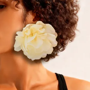 Close-up of oversized cream fabric flower earring on a female model