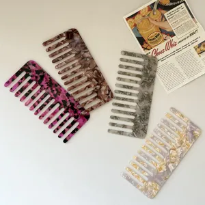 Detailed close-up of wide tooth acetate hair combs in marble patterns, elegant daily hair styling tool.