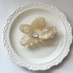 Detailed close-up view of an exquisite acetate butterfly hair claw clip featuring a rhinestone.