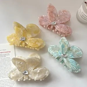 Close-up detail of acetate butterfly flower hair claws with crystal center, elegant design.