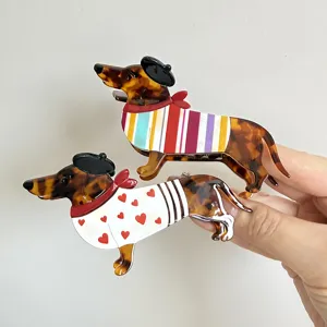 Vista detallada de lindas pinzas de acetato con carey y diseño de perro salchicha.