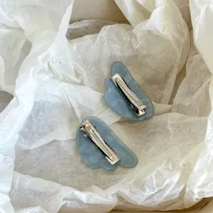 Blue asymmetric acetate hair clip detail close-up, stylish side clip for bangs and styling.