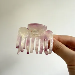 Elegant acetate hair claw clip with unique purple marbled pattern, secure double-row teeth.