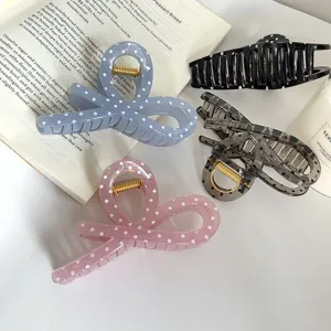 Primo piano di graziose pinze per capelli con pois e fiocco in vari bellissimi colori.
