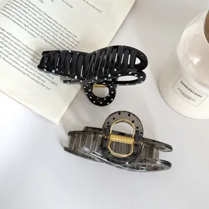 Elegante pinza per capelli grande a pois per donna, accessorio per capelli nero e grigio chic.
