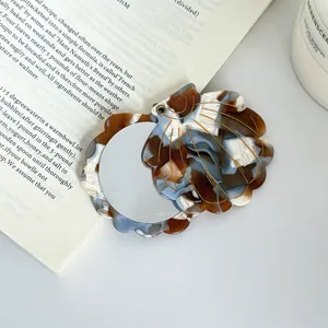 Exquisite shell-shaped portable makeup mirror detail, compact folding design, chic aesthetic.