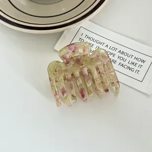 Medium acetate hair claw clip with pink and green marble pattern for stylish daily hairstyles.