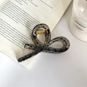 Primo piano del fermaglio per capelli a nastro a pois grigi trasparenti, dettaglio.