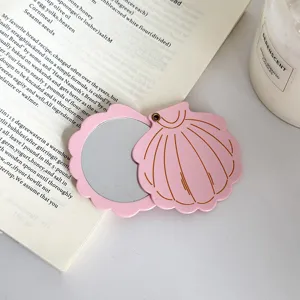 Pink shell pocket mirror detail shot, compact foldable cosmetic mirror with double-sided glass.