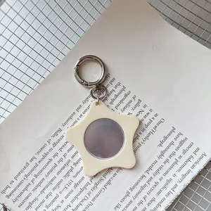 Close-up detail view of the cute star-shaped mirror keychain placed nicely on a book page.