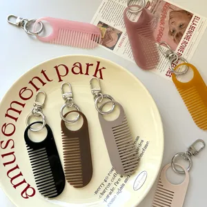 Detail van schattige mini effen kam sleutelhangers in diverse kleuren draagbaar.