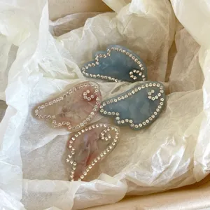 Rhinestone angel wing hair clip, exquisite acetate side barrette displayed on white tissue.