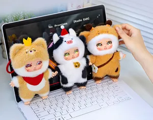 Gros plan de mignonnes figurines de poupées en peluche et vinyle sur clavier d'ordinateur.