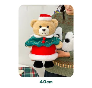 Close up detail of a cute Christmas plush teddy bear wearing a festive Santa hat and cape.