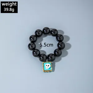 Vue détaillée du bracelet d'Halloween en perles noires avec une petite breloque crâne