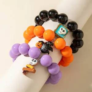 Détail de bracelets d'Halloween en perles acryliques noires, oranges et violettes avec charms