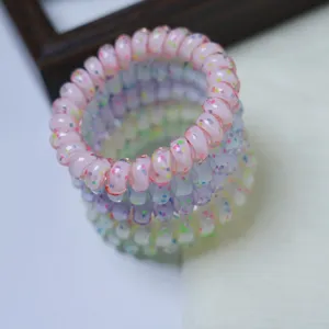 Close-up detail of colorful dotted telephone wire hair tie, soft and seamless accessory.