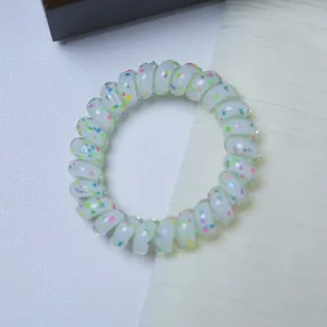 Colorful polka dot telephone wire hair tie detail, transparent resin stretch hair band.