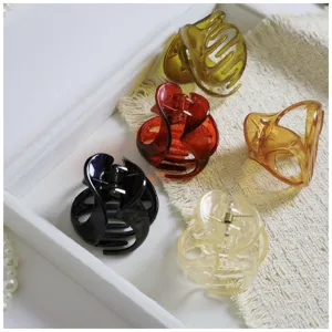 Close-up details of stylish irregular resin hair claw clips, showcasing unique colors and textures.