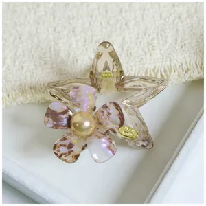 Detailed view of an acetate star floral hair claw clip with pearl center, elegant hair accessory.