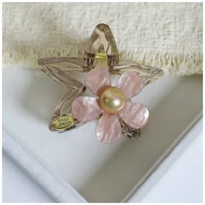 Acetate star hair claw clip featuring a pink flower and pearl center for women elegant styling.