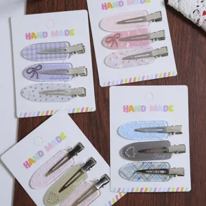 Detailed shot of cute Korean style hair clips set with plaid patterns and sparkling hearts.