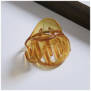 Amber resin hair claw clip detail, translucent medium shark clip for half up bun styling.