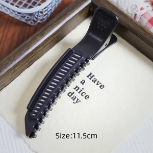 Detail view of black plastic hair root volumizing duckbill clip, measuring 11.5 cm.