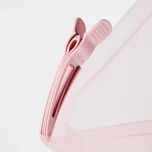 Close-up of pink plastic hair root volumizing clip detail showing durable striped texture.