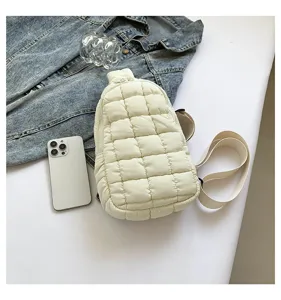 Detailed view of white quilted puffer sling bag, soft cloud crossbody bag with zipper.