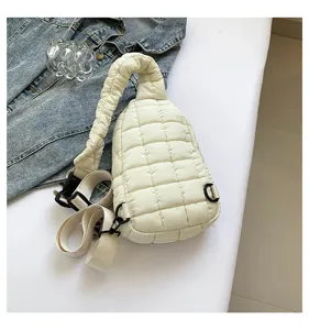 White quilted puffer sling bag detail showcasing soft wrinkled strap and diamond pattern texture.