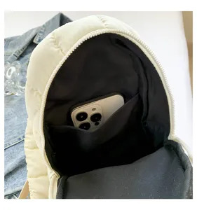 Detailed view of white quilted chest bag interior, showing phone pocket and capacity design.