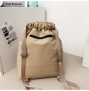 Vue détaillée du sac à dos cordon en nylon kaki, avec poche zippée avant et bretelles.
