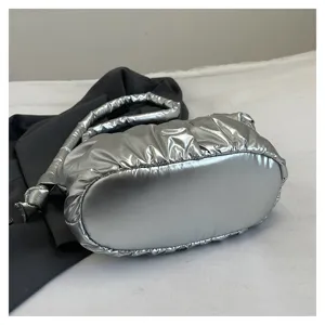 Silver metallic puffer shoulder bag detail, stylish pleated nylon bucket handbag close-up.